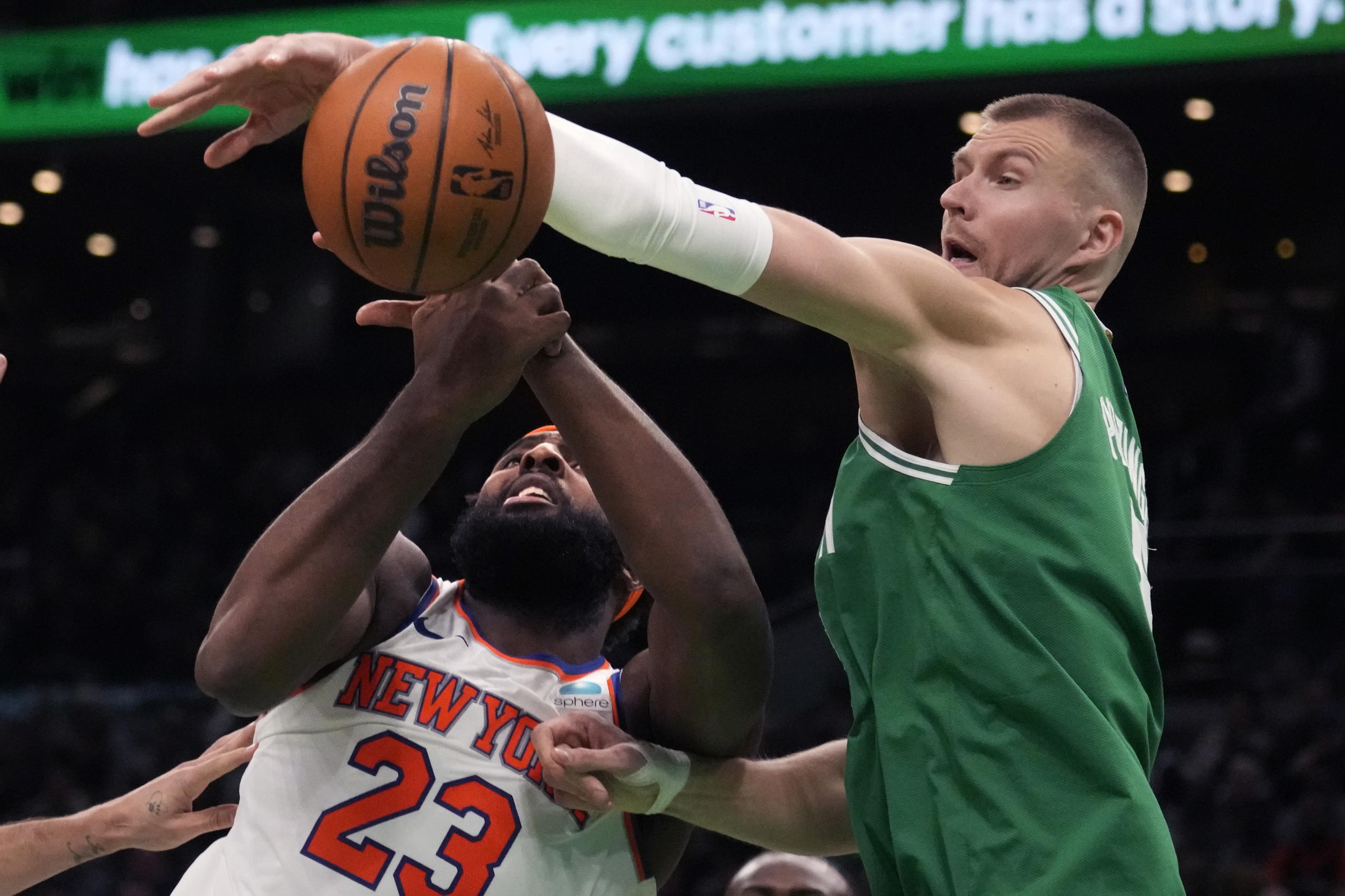 El pívot Kristaps Porzingis, derecha, de los Celtics de Boston, bloquea un tiro de Mitchell Robinson (23), de los Knicks de Nueva York, durante la segunda mitad del juego de baloncesto de la NBA.