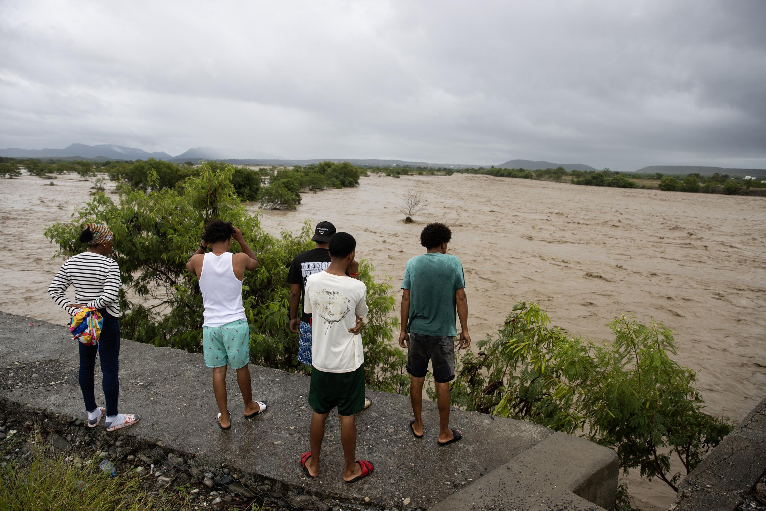 Personas observan el río Ocoa, que luce un inmenso caudal producto de las intensas lluvias, este 18 de noviembre de 2023 en Palmar de Ocoa (República Dominicana). EFE/Orlando Barría
