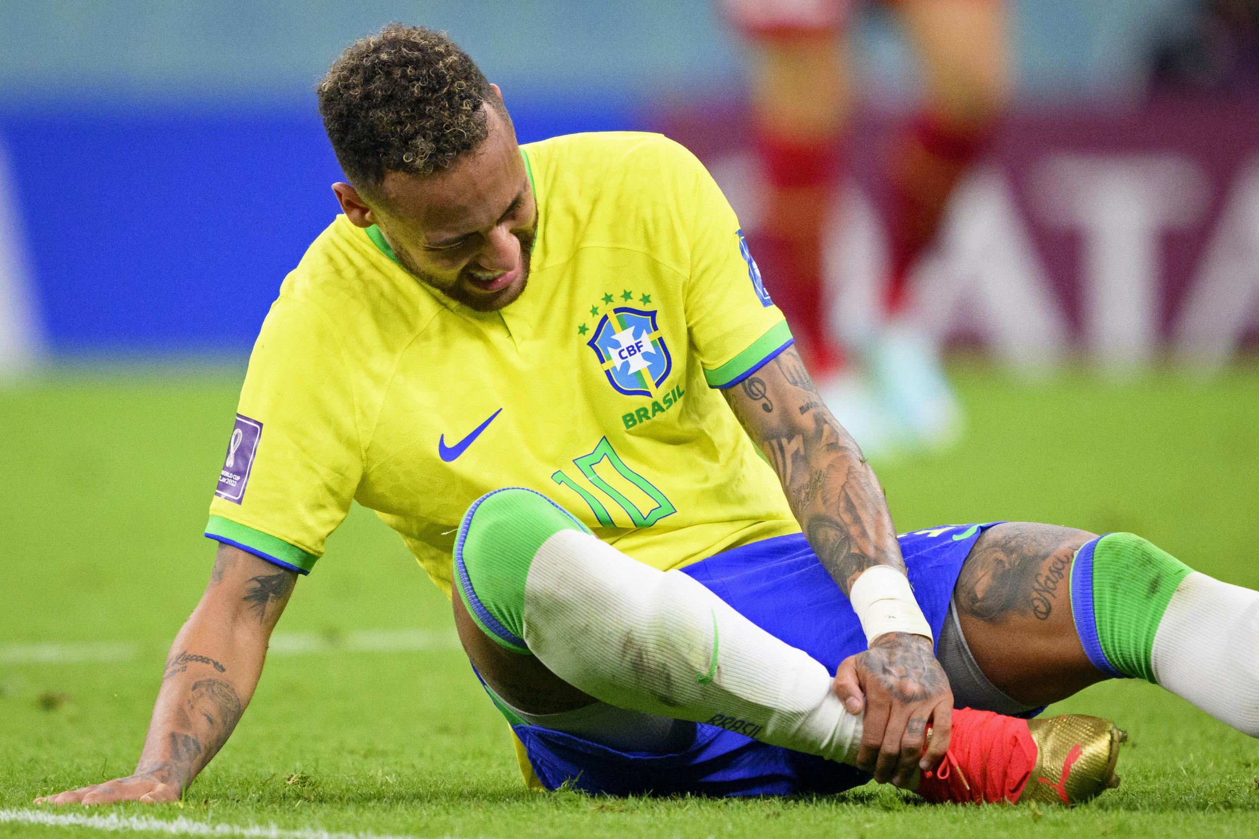El delantero brasileño Neymar se sujeta el tobillo durante el partido contra Serbia por el Grupo G del Mundial, el jueves 24 de noviembre, en Lusail, Qatar. (Laurent Gillieron/Keystone vía AP)