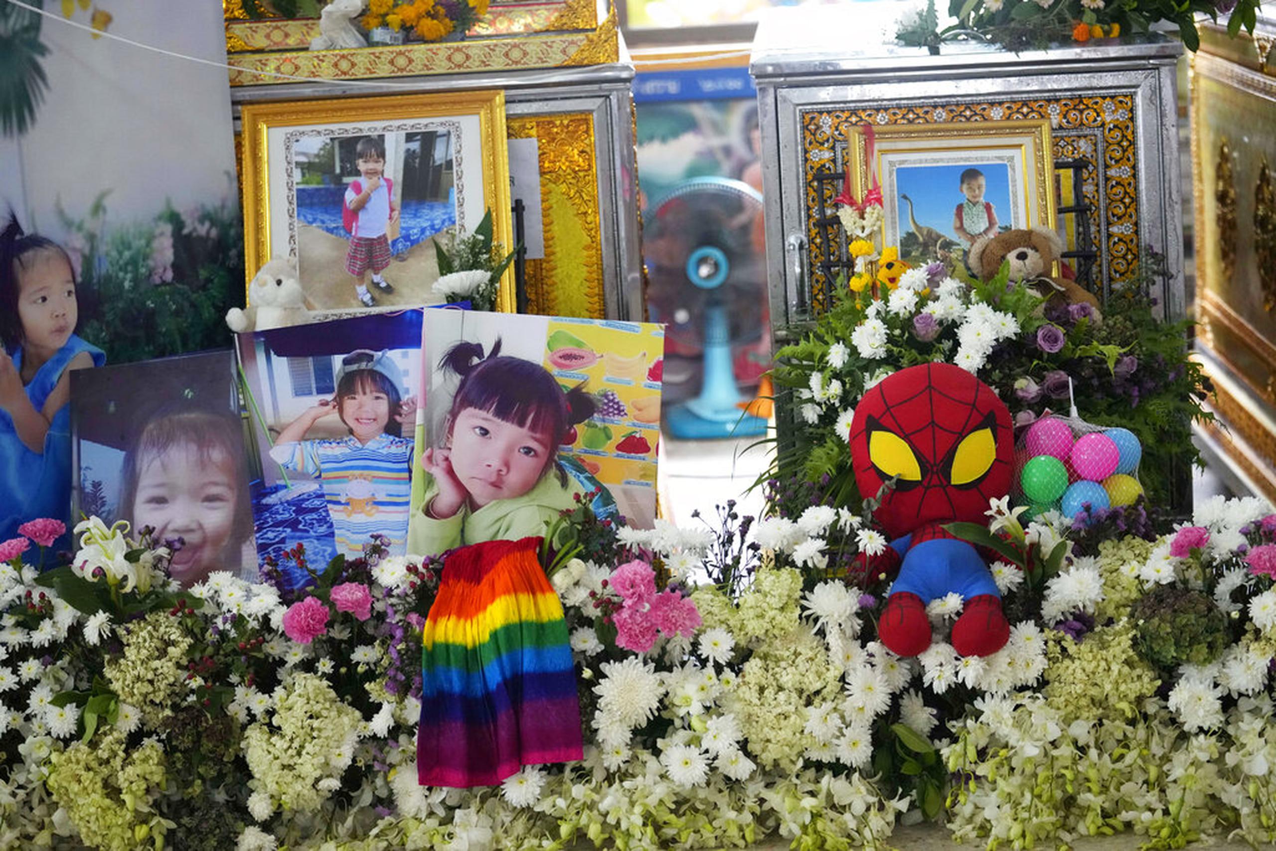 Fotos de las víctimas alrededor de ataúdes dentro del templo Wat Rat Samakee en Uthai Sawan, Tailandia, el 10 de octubre de 2022.