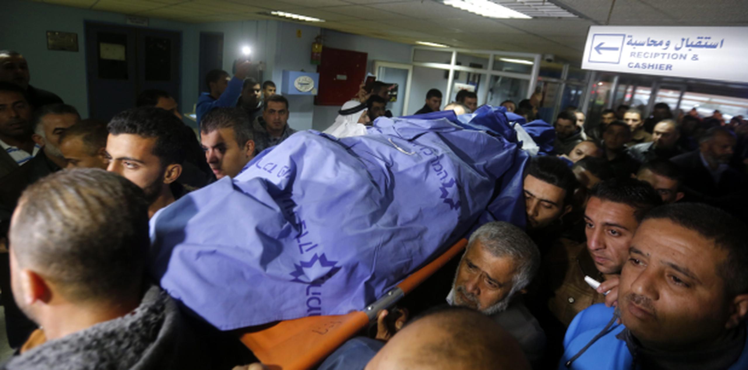 Dolientes de un palestino fallecido en un enfrentamiento con tropas israelíes cargan su cuerpo al salir de un hospital. (AP)