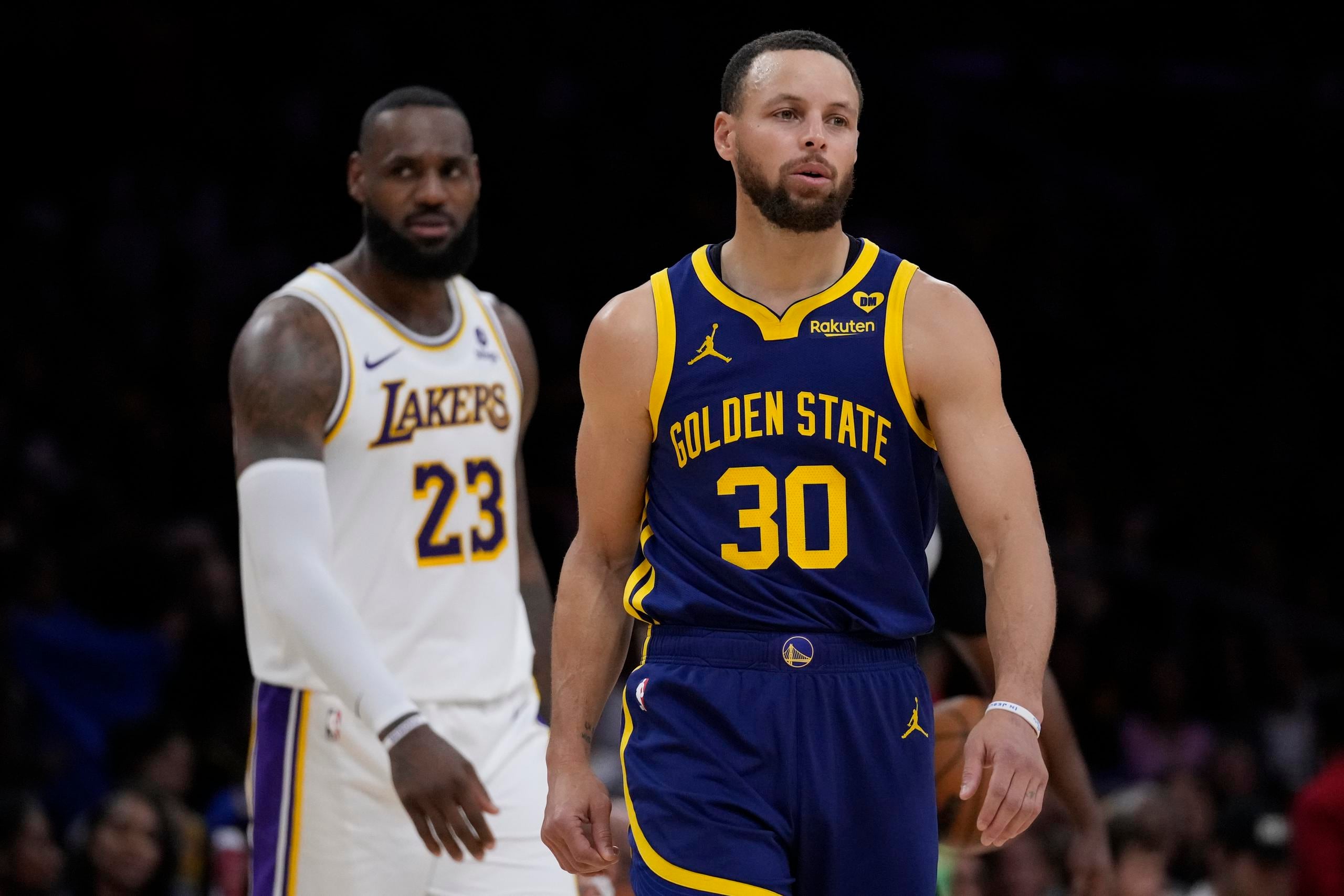 El escolta de los Warriors de Golden State, Stephen Curry (30), y el alero de los Lakers de Los Angeles, LeBron James (23), después de que el juego se detuvo debido a un mal funcionamiento del reloj de tiro durante la segunda mitad del partido de baloncesto de la NBA contra los Golden State Warriors en Los Ángeles, el sábado 16 de marzo de 2024.