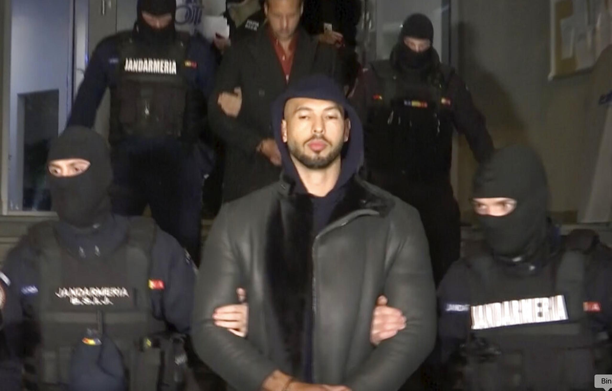 En esta captura tomada de un video publicado por Observator Antena 1, Andrew Tate es llevado por la policía en el área de Ilfov, al norte de Bucarest, Rumania, el 29 de diciembre de 2022.