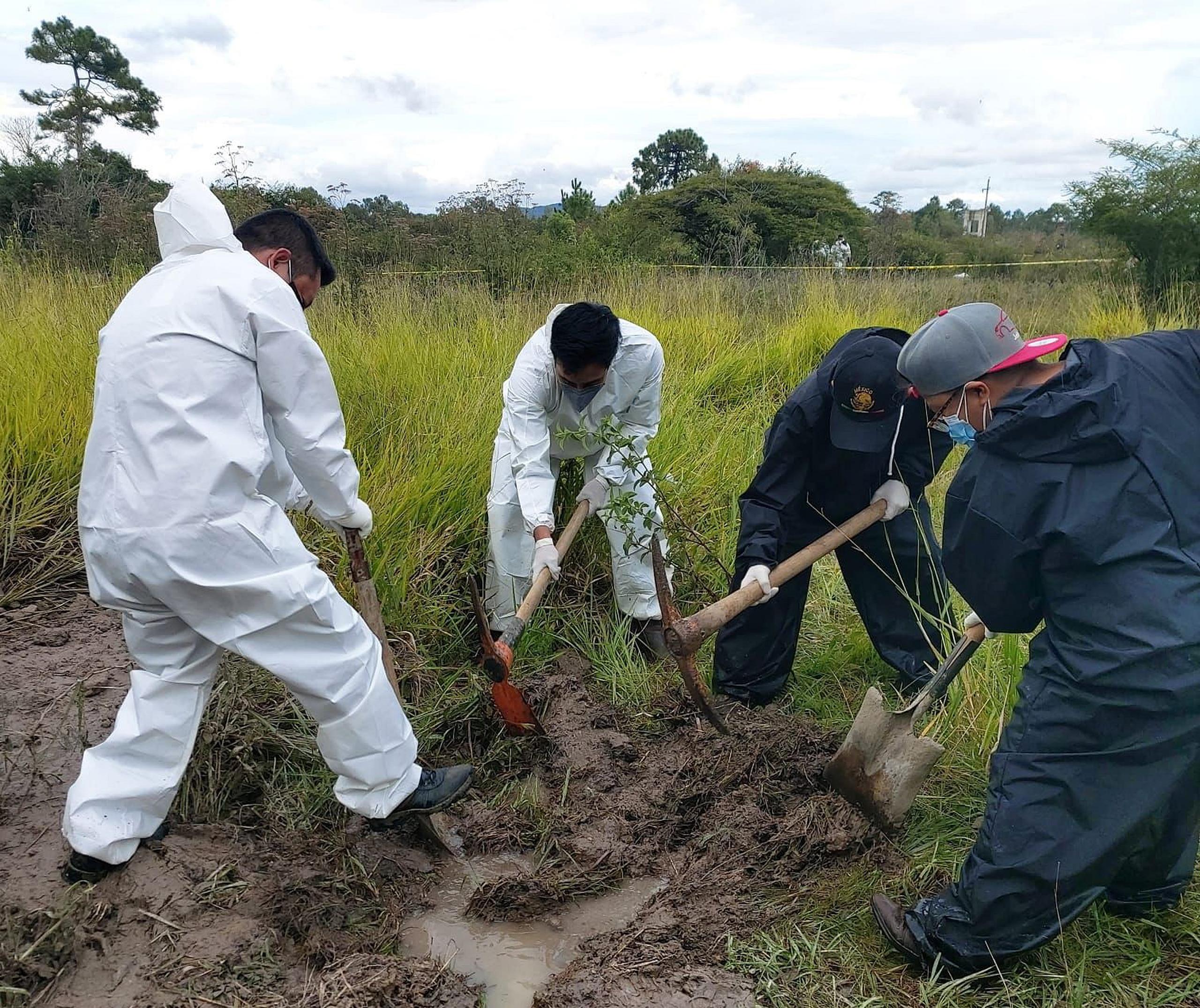 Fotografía cedida hoy, por la Fiscalía del estado de Chiapas, donde se observa a peritos forenses laborando en la zona donde encontraron una fosa con restos humanos, en la comunidad de Comitán en el estado de Chiapas (México). EFE/Fiscalía del estado de Chiapas
