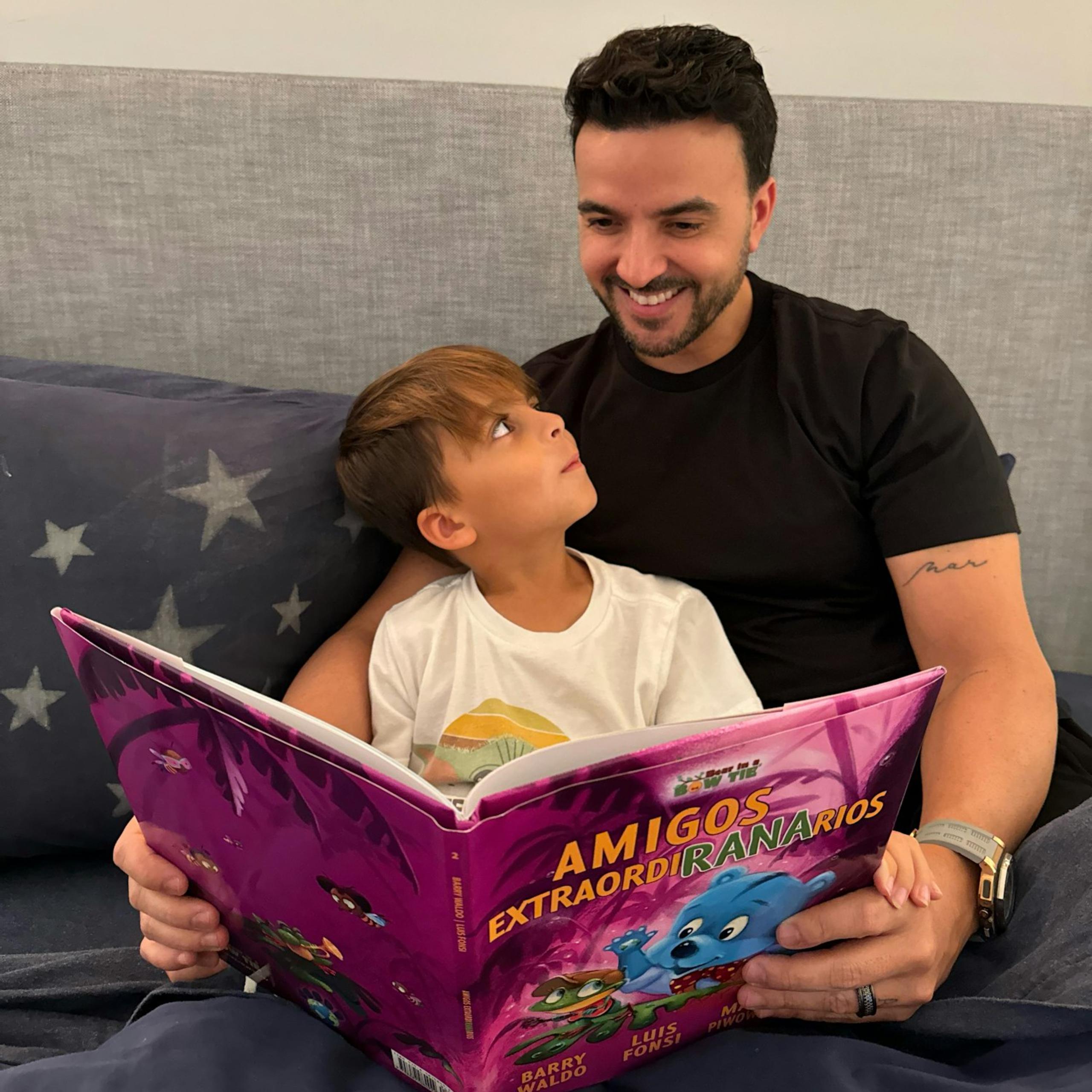 Fotografía cedida por Rondene PR donde aparece el cantante puertorriqueño Luis Fonsi y su hijo mientras hojean las páginas del libro infantil 'Amigos ExtraordiRANArios' ('UnFROGettable Friends'). EFE/Rondene PR
