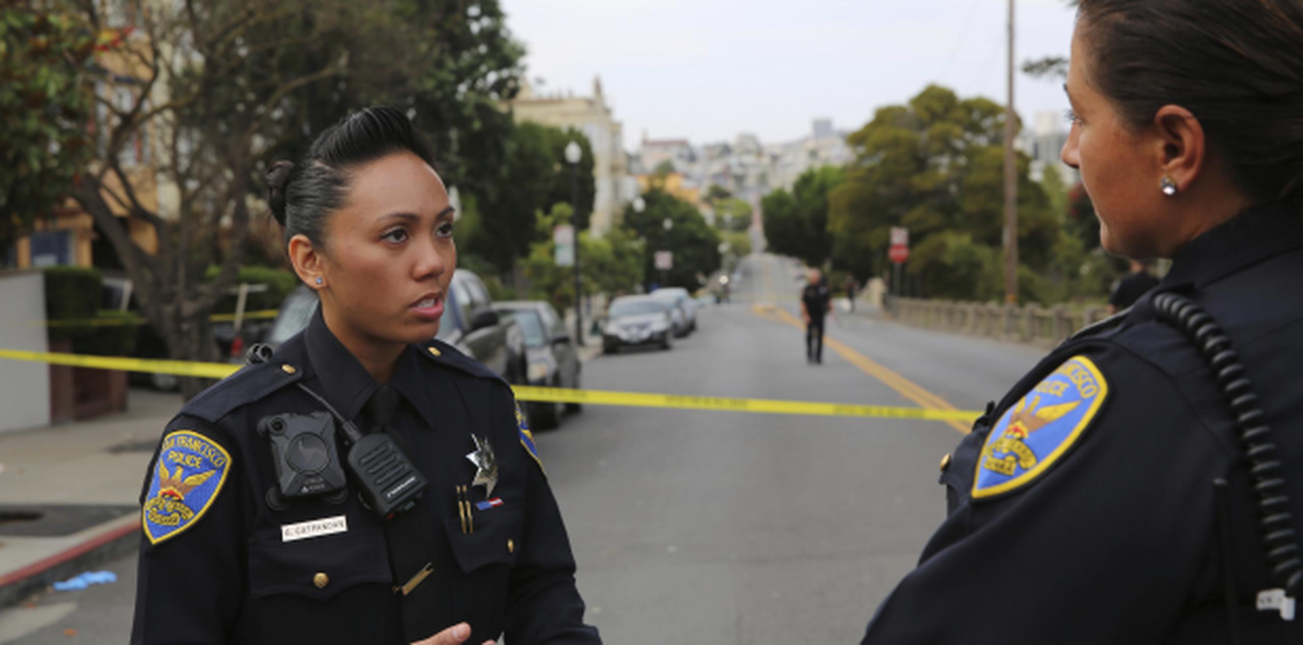 Grace Gatpandan, mujer policía de San Francisco hablaba con otro agente luego de reportes de disparos en el parque Dolores, de San Francisco. (AP Foto/Linda Wang)