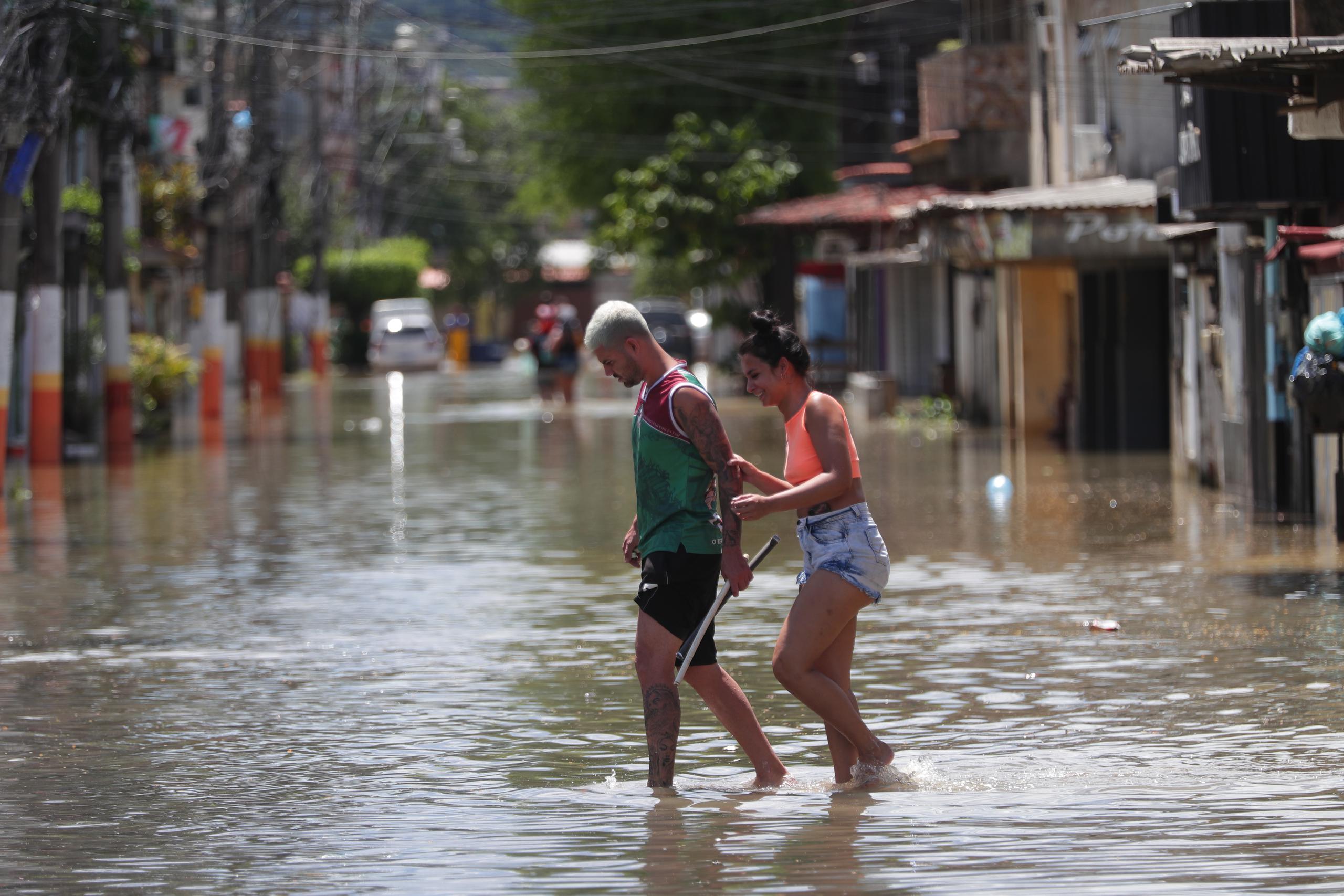 Habitantes transitan por una calle inundada tras las lluvias en el área metropolitana de Río de Janeiro, en Brasil. (Archivo/EFE/André Coelho)