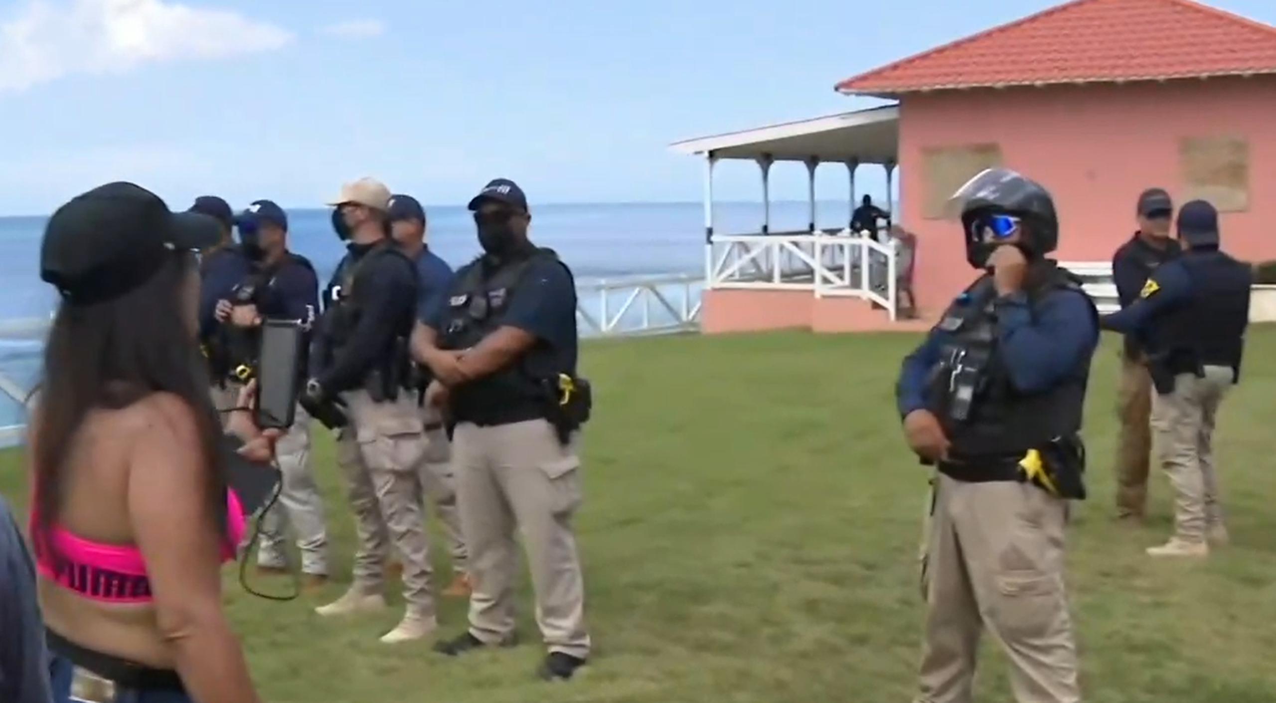Una línea de Policía separa a los manifestantes de la propiedad que alegan fue construida de manera ilegal en la zona marítimo terrestre en Aguadilla.