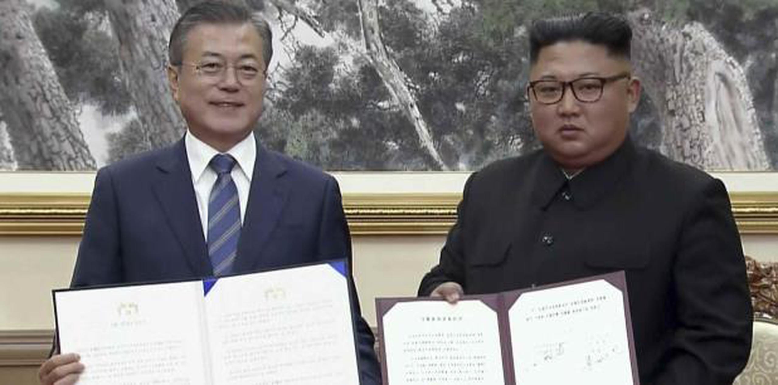 El presidente de Corea del Sur, Moon Jae-in (izquierda), y el líder norcoreano Kim Jong Un posan tras la firma de documentos. (AP)