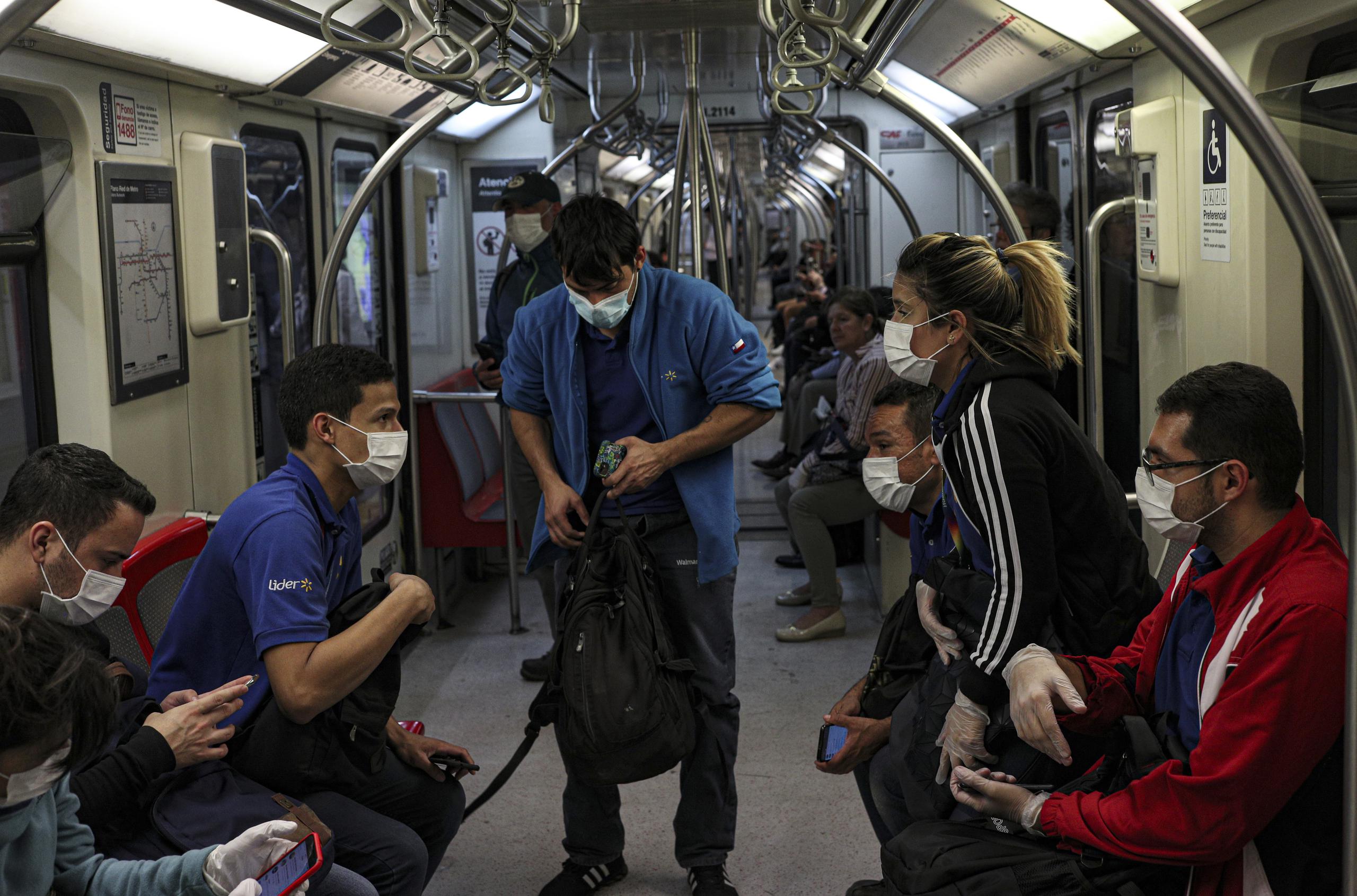 Los trabajadores de supermercados usan mascarillas como precaución contra la propagación del nuevo coronavirus en el metro de Santiago de Chile.