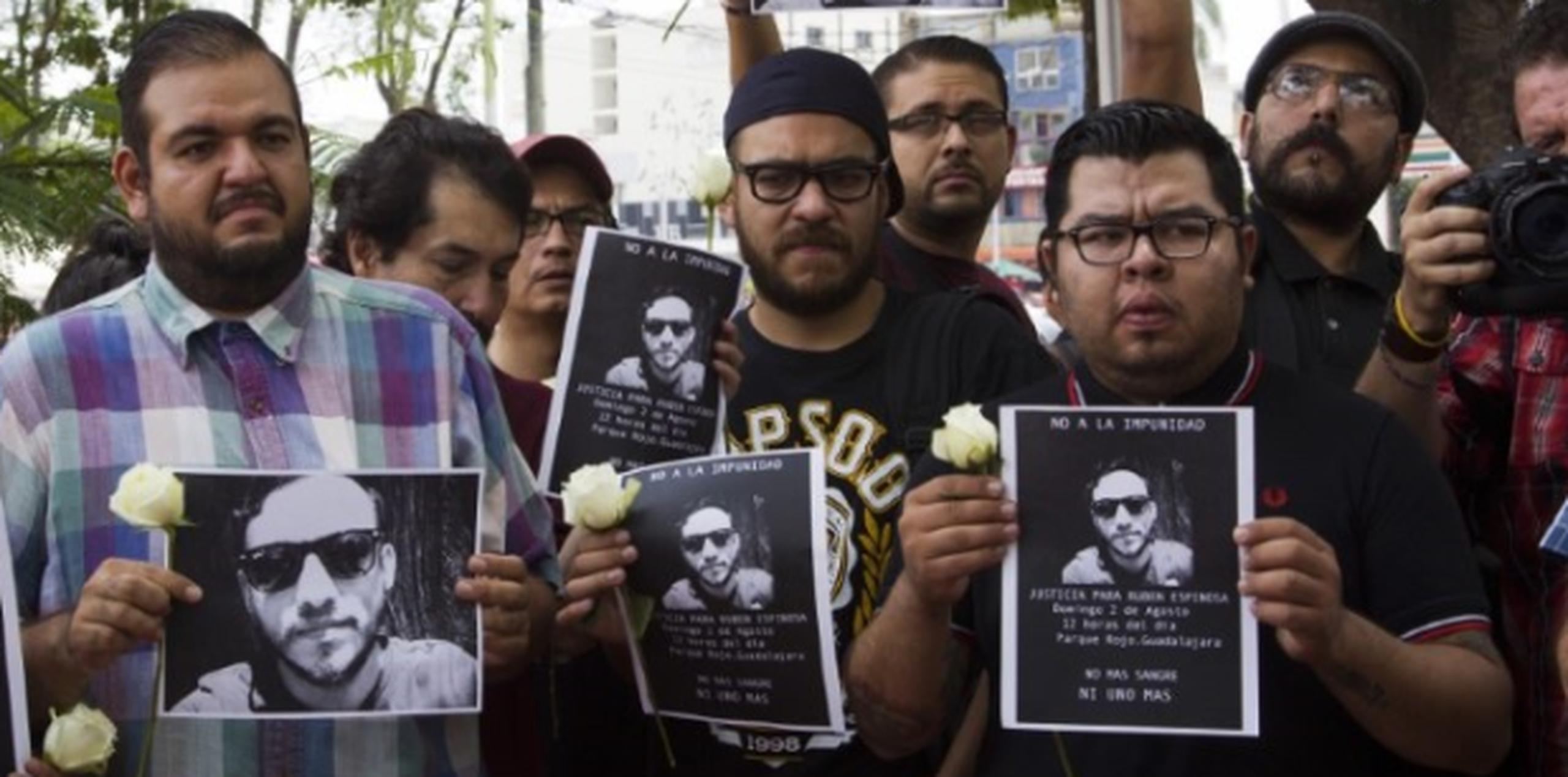 Fotoperiodistas mexicanos realizan una manifestación contra la violencia con flores y fotos de su colega asesinado. (AFP)