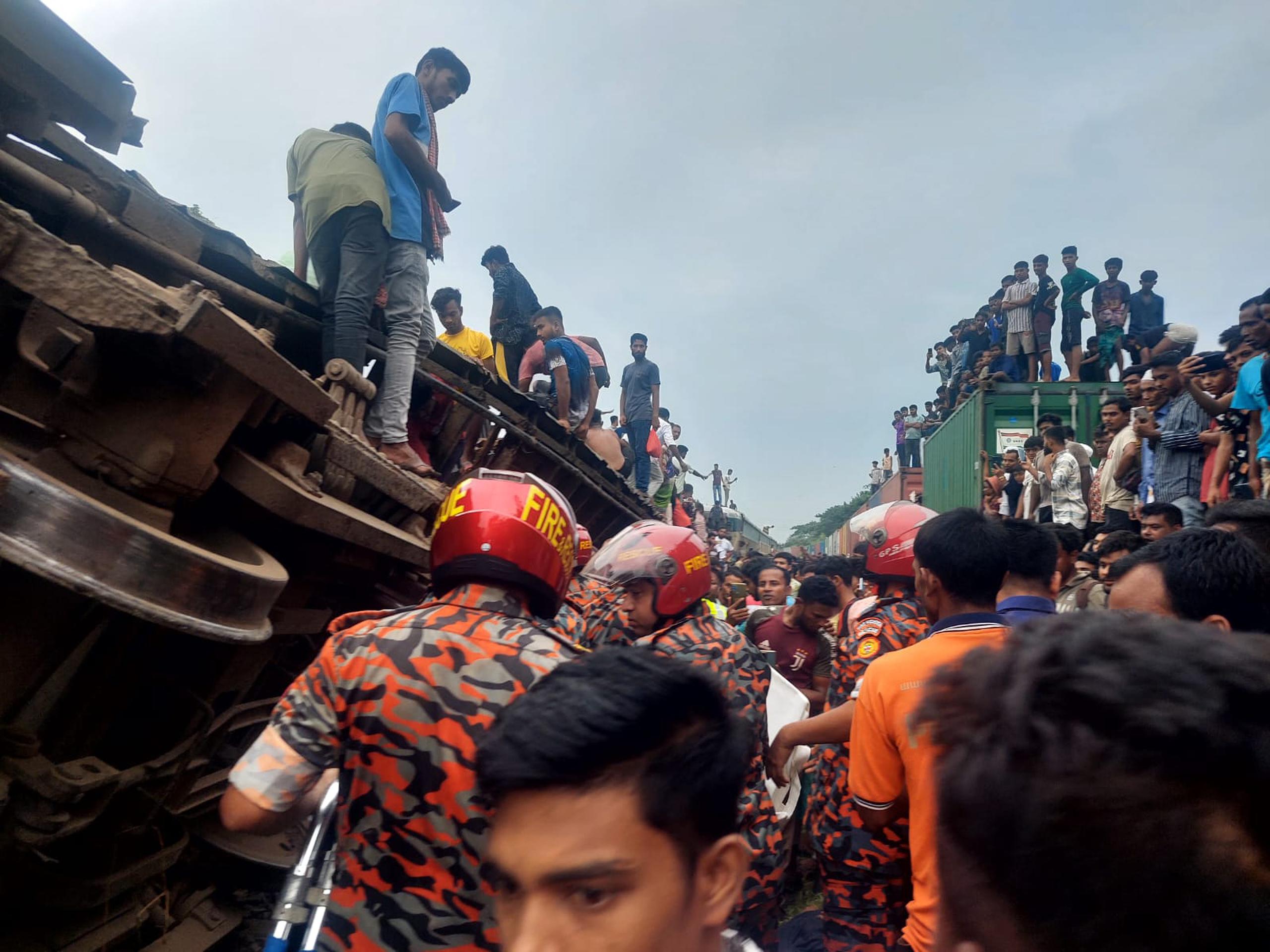 Esta fotografía proporcionada por el Servicio de Bomberos y el Departamento de Defensa Civil de Bangladesh muestra a los rescatistas y otras personas después de que un tren de carga chocó contra un tren de pasajeros en Bhairab, Bangladesh, el lunes 23 de octubre de 2023.(Foto, Servicio de Bomberos de Bangladesh y Departamento de Defensa Civil vía AP)