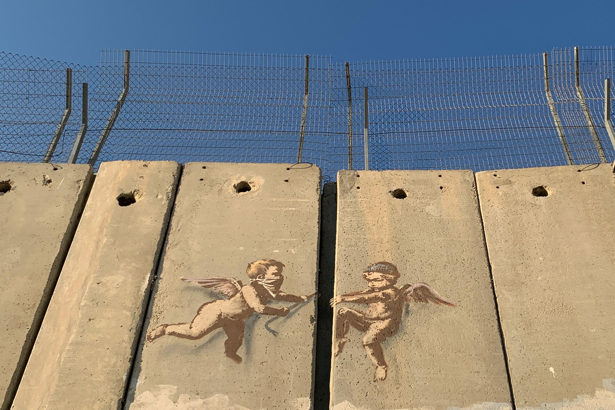 Vista de una obra del artista británico Banksy sobre el muro que divide Israel de Cisjordania en Belén. EFE/ Yemeli Ortega
