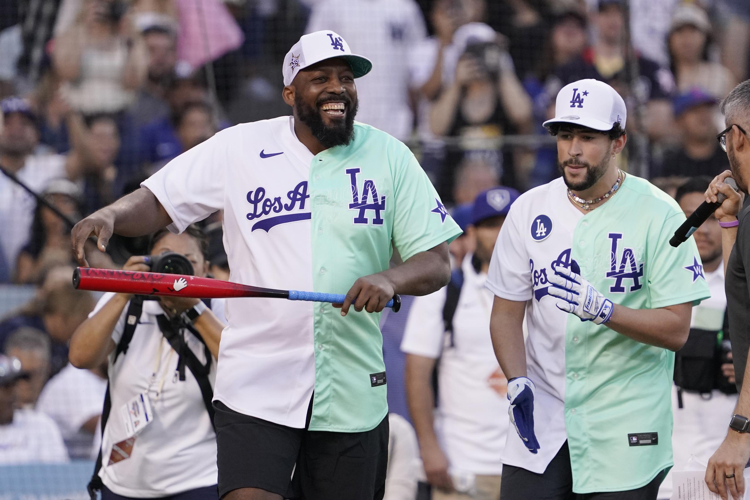 Former Major League Baseball player Vladimir Guerrero smiles next to Rapper and Singer Bad Bunny during the MLB All Star Celebrity Softball game, Saturday, July 16, 2022, in Los Angeles. (AP Photo/Mark J. Terrill)