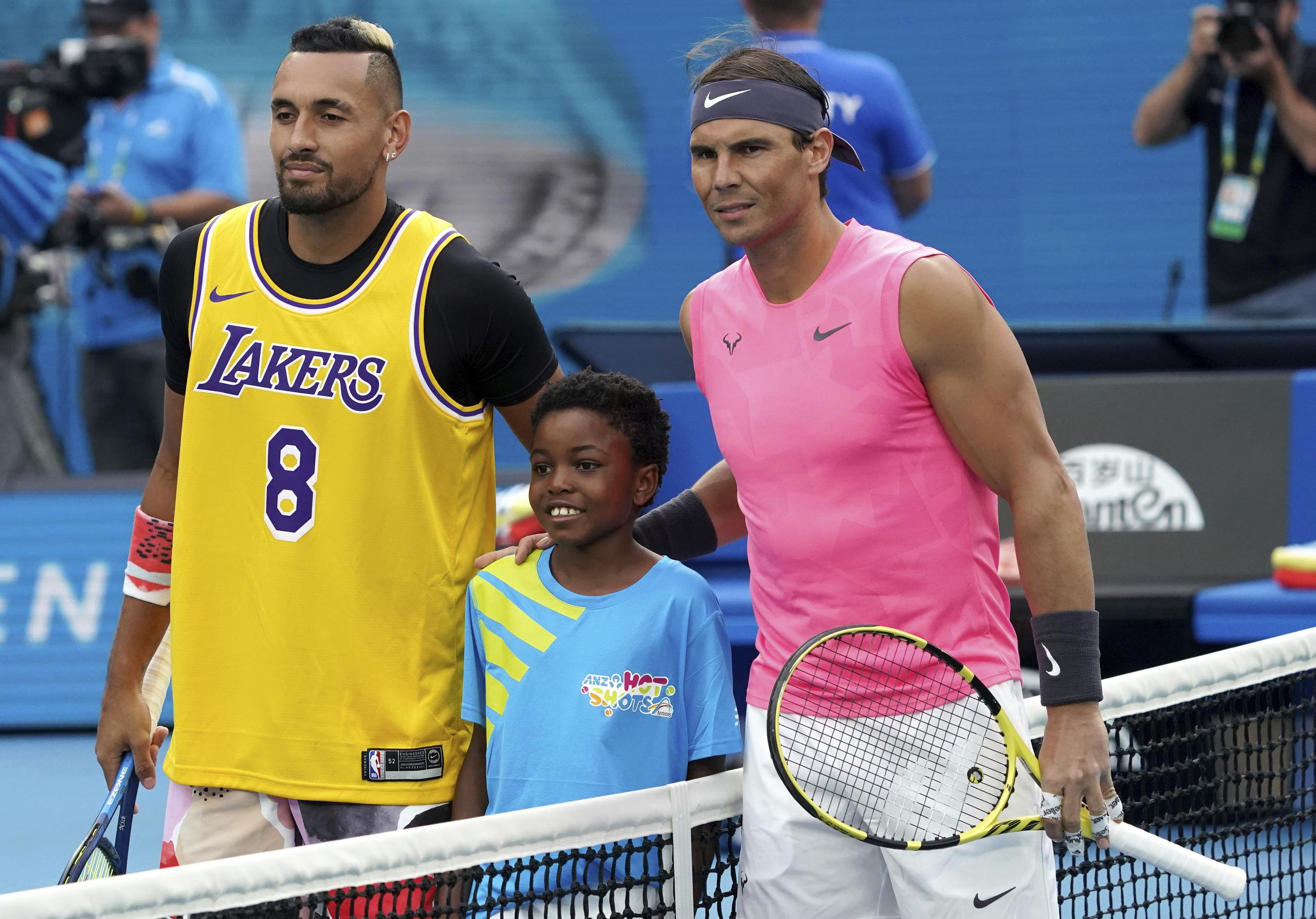 Con una camisa en honor a Kobe Bryant, el australiano Nick Kyrgios posa con un niño y con el español Rafael Nadal previo a su juego en el Abierto de Australia. (AP Photo/Lee Jin-man)
