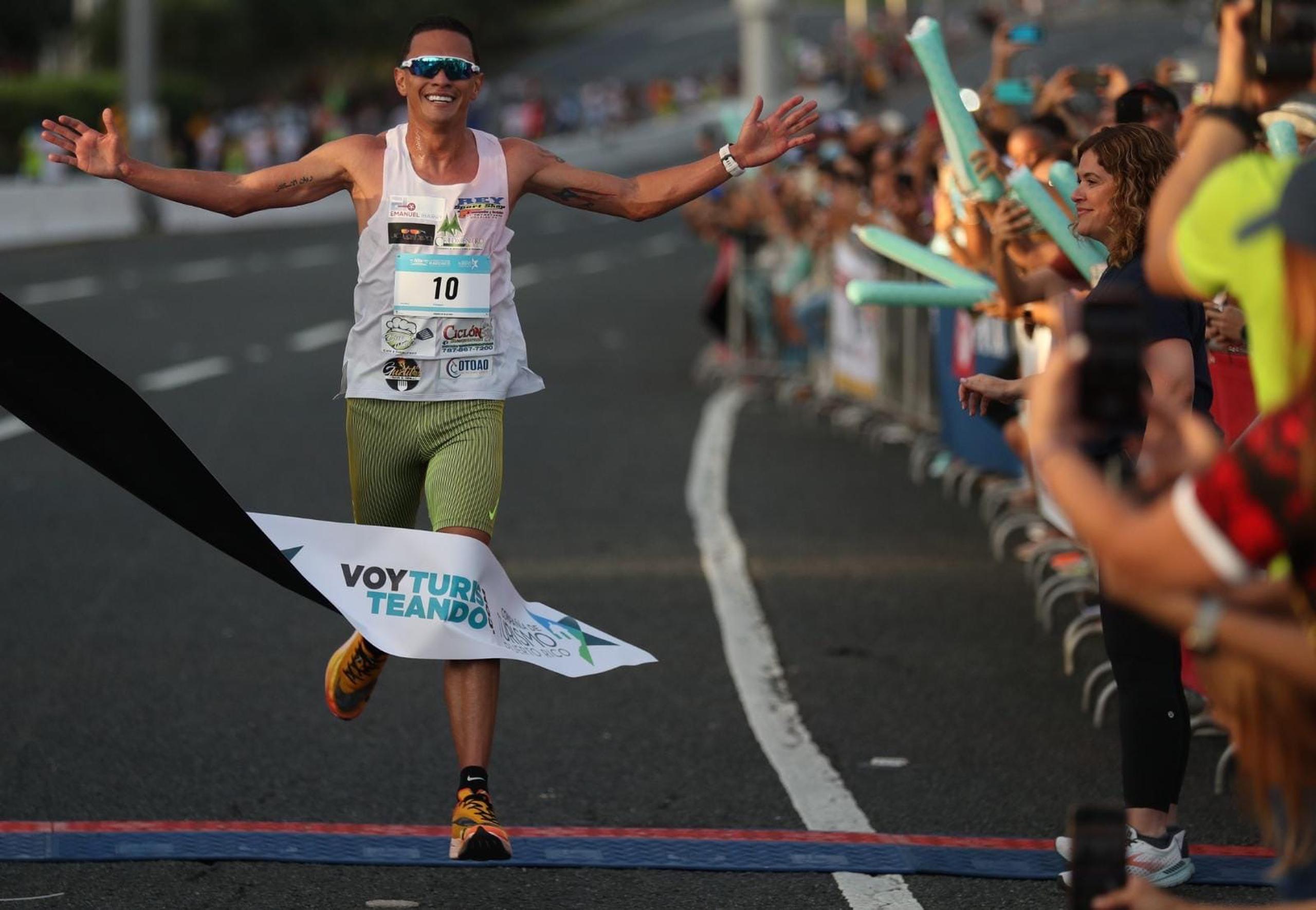 Alexander Torres levanta sus brazos al cruzar la meta para convertirse en el histórico primer ganador del Puerto Rico 10K Run.
