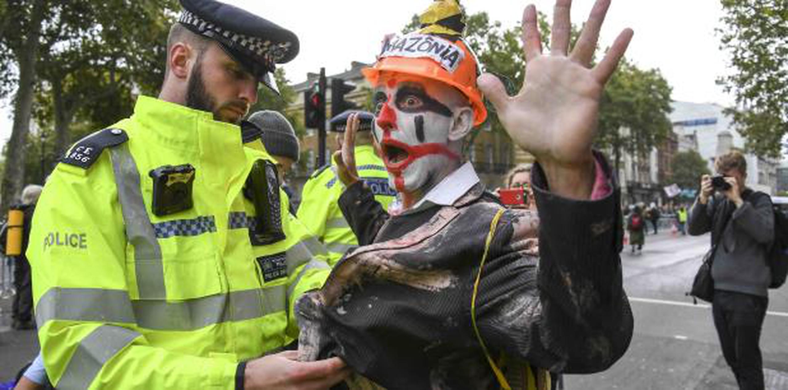 Arrestan a un manifestante vestido de payaso. (AP)